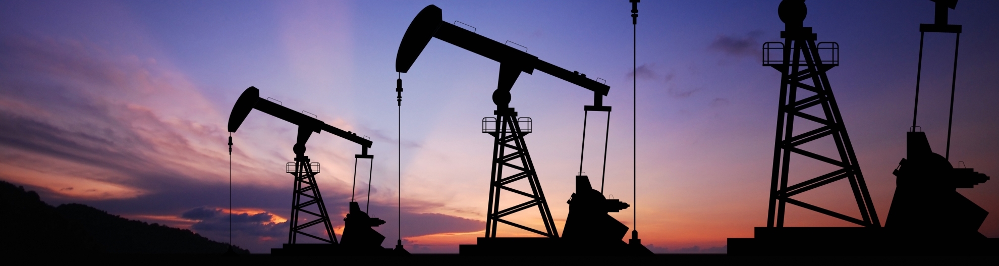 3 oil pumps in field at sunrise